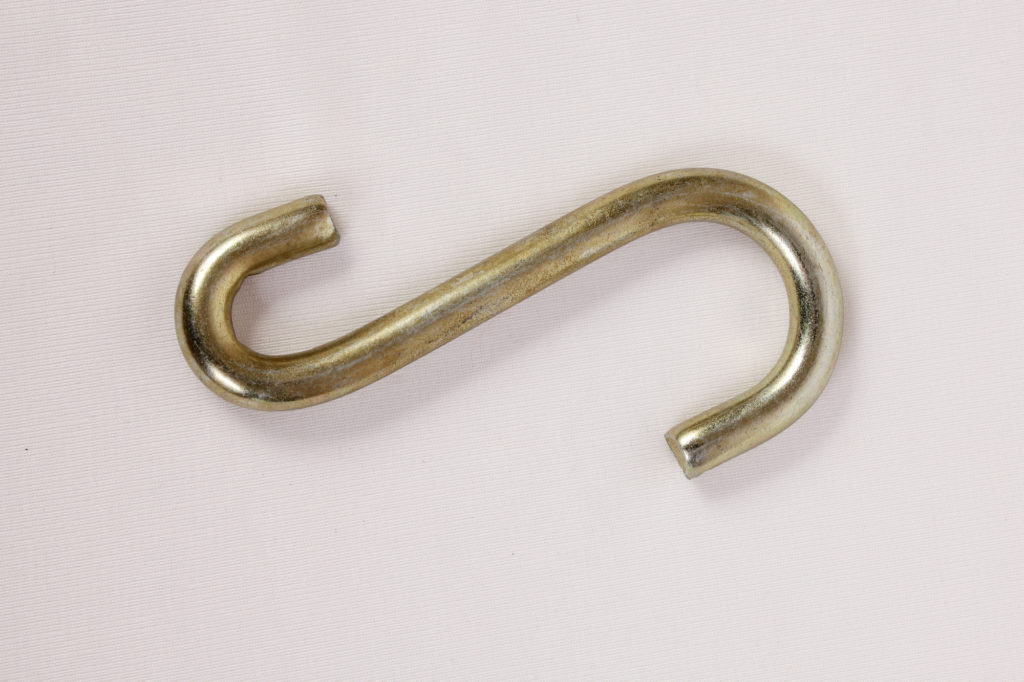 An s-shaped metal hook on white background
