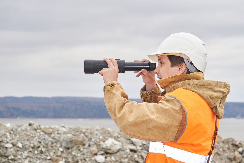 An engineer using a telescope