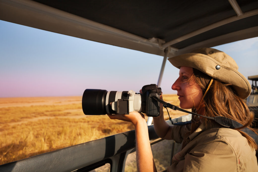 Woman taking photos from safari jeep