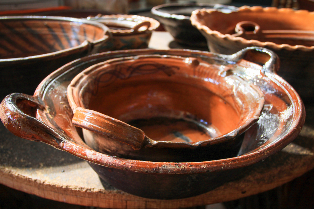 Traditional Brown Clay Cooking Pots Stacked up on Wood Table